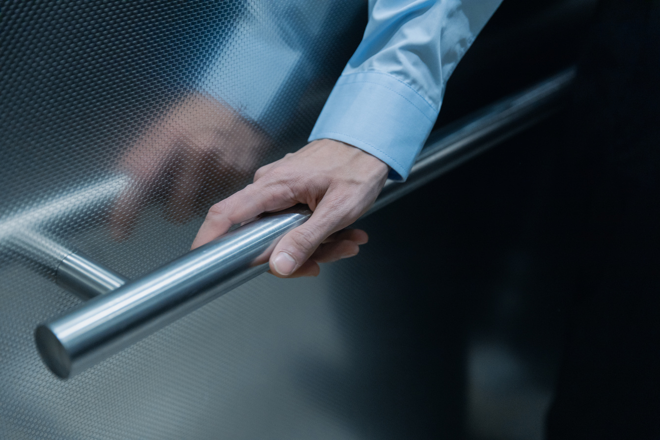 Hand Holding on Elevator Handrail 